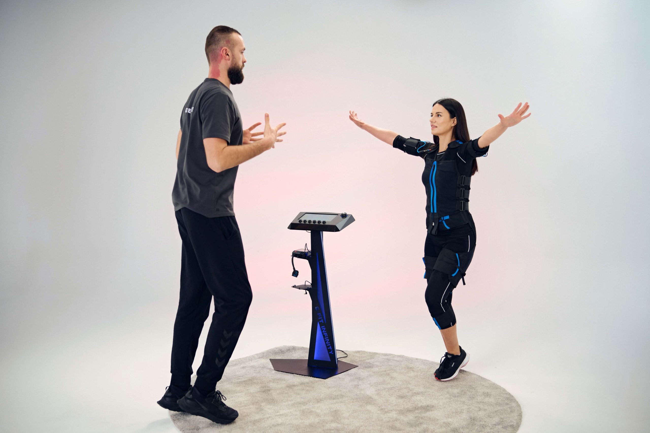 Woman happily working out in ems suit stand pose